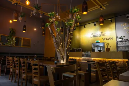Comcha Vegan Restaurant Innenbereich mit geschmackvollem Holzambiente und Lichterbaum